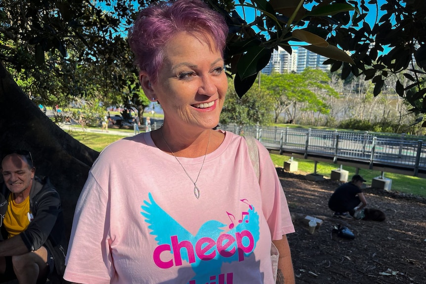 A woman with pink hair wears a pink Tshirt with CHEEP TRILL written on it