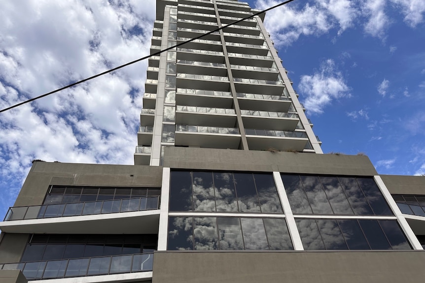 A 16-storey apartment building beneath a patchy sky.