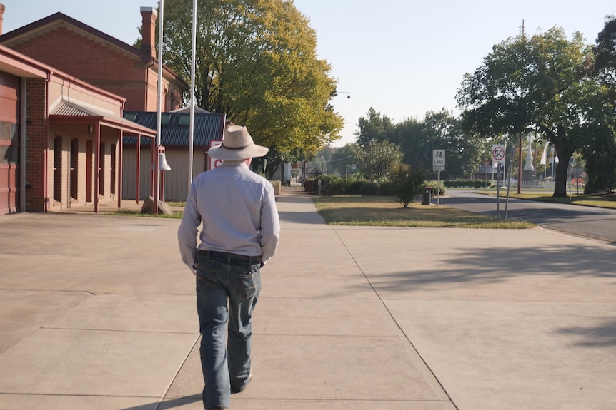 A man walks up a country street 