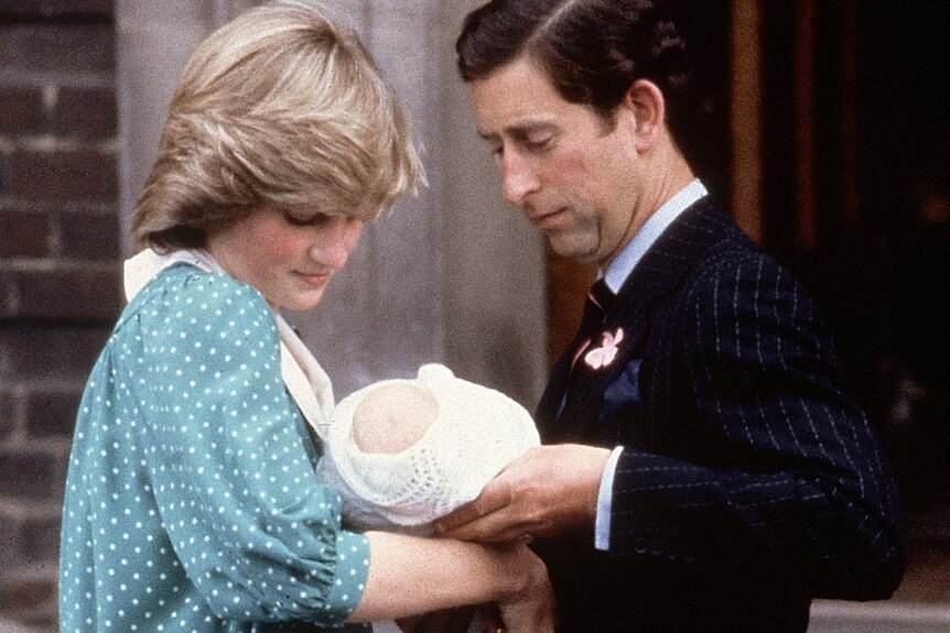 Princess Diana and Prince Charles hold baby Prince William.