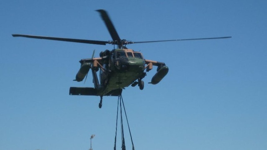 A Black Hawk helicopter delivers food to flood-stricken Emerald residents
