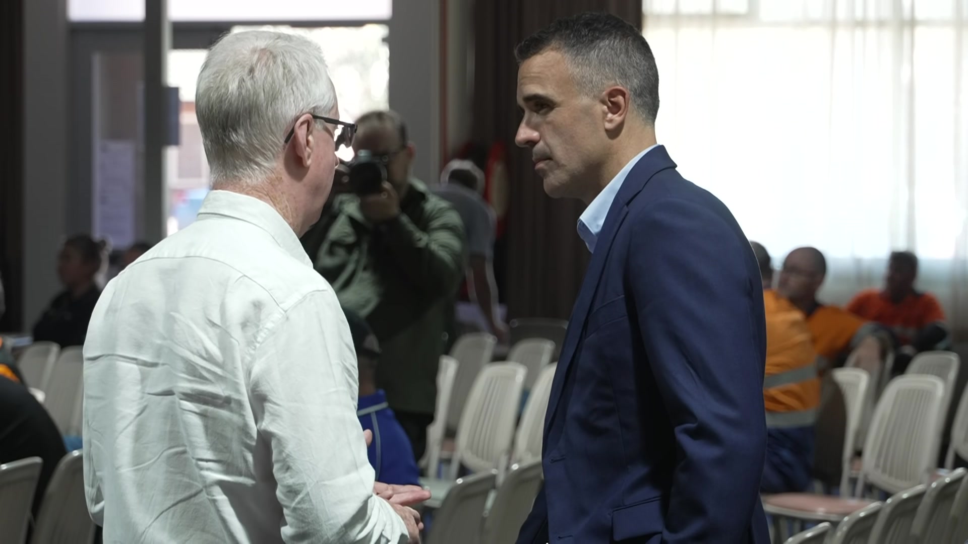 Peter Malinauskasは、債権者の会議が始まる前に、白いビジネスシャツを着た男性と話をします