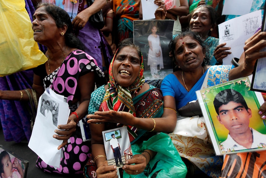 Women hold photos of young men allegedly disappeared in Sri Lanka