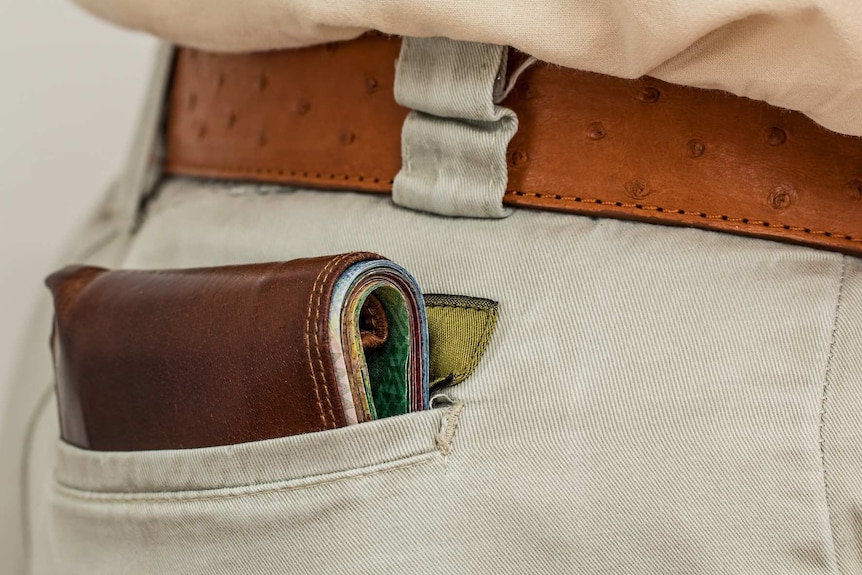 A generic photo of a wallet filled with money in a back pocket.