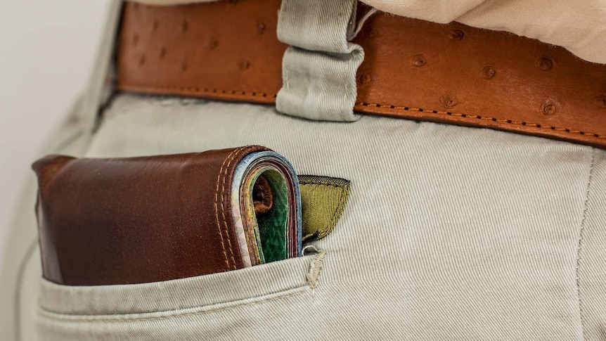 A generic photo of a wallet filled with money in a back pocket.