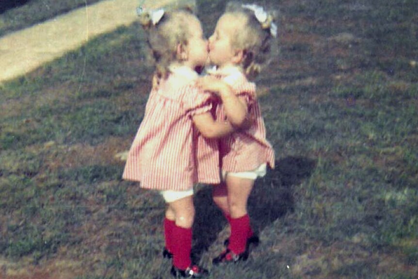 Twin toddler girls in matching red and white outfits 