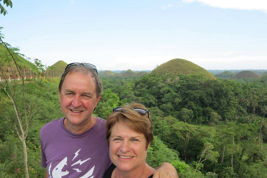 Paul van Wensveen stands with a woman with mountain views behind them