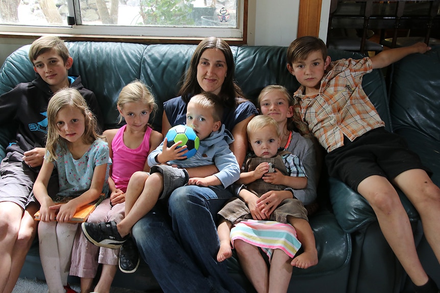 Launceston mum Anita Morgan sits on the couch with her seven children