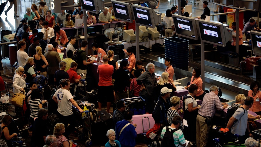 Chaos... Qantas passengers at check-in counters at Singapore airport