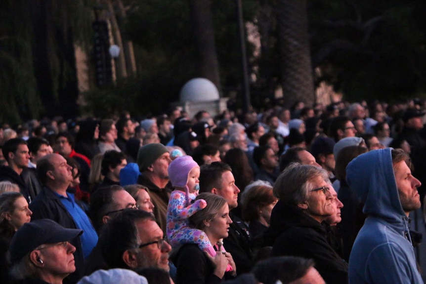 A crowd of people watches on during a dawn service at Kings Park.