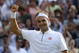 Federer raises his fist and smiles.
