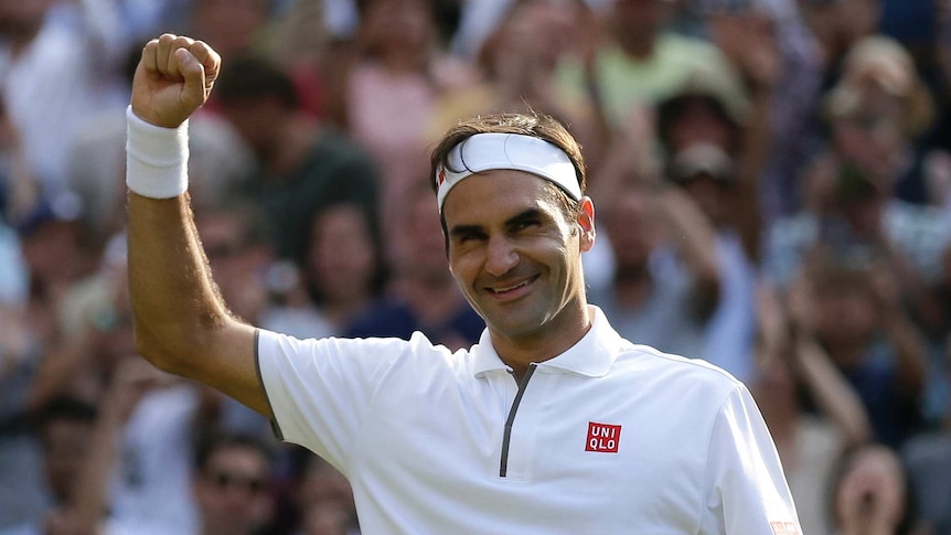 Federer raises his fist and smiles.