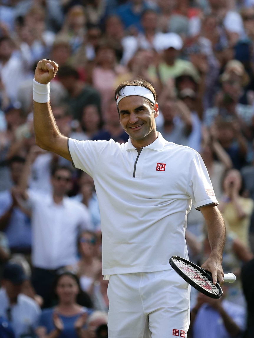 Federer raises his fist and smiles.