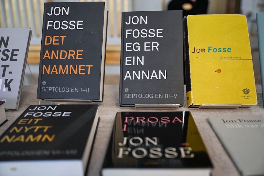 A collection of books with black covers and write writing, written by Jon Fosse, on display.