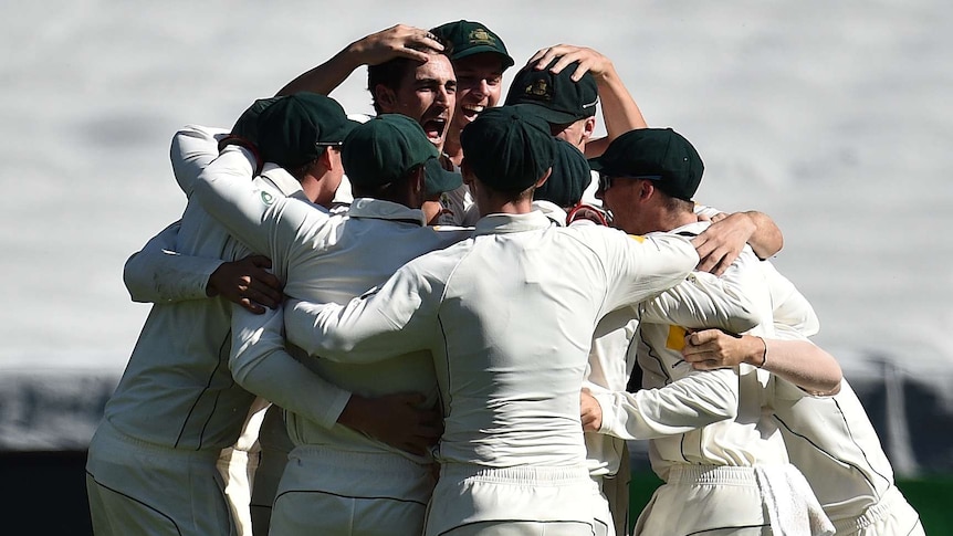 Australian players swarm Mitchell Starc as he ends the MCG Test