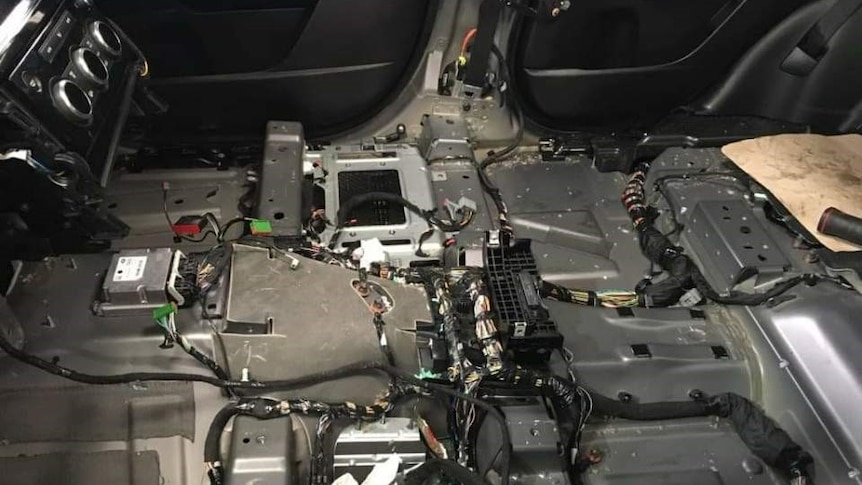 L'interno dell'auto, dopo aver rimosso i sedili e le finiture, rivela il cablaggio e l'elettronica.