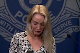 A woman at a police press conference. 