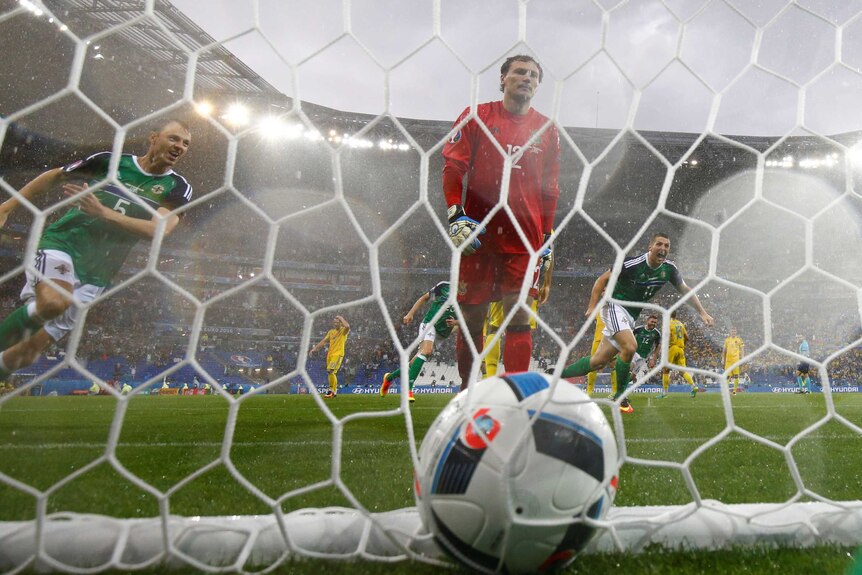 Jonny Evans celebrates Northern Ireland's goal as Andriy Pyatov looks on