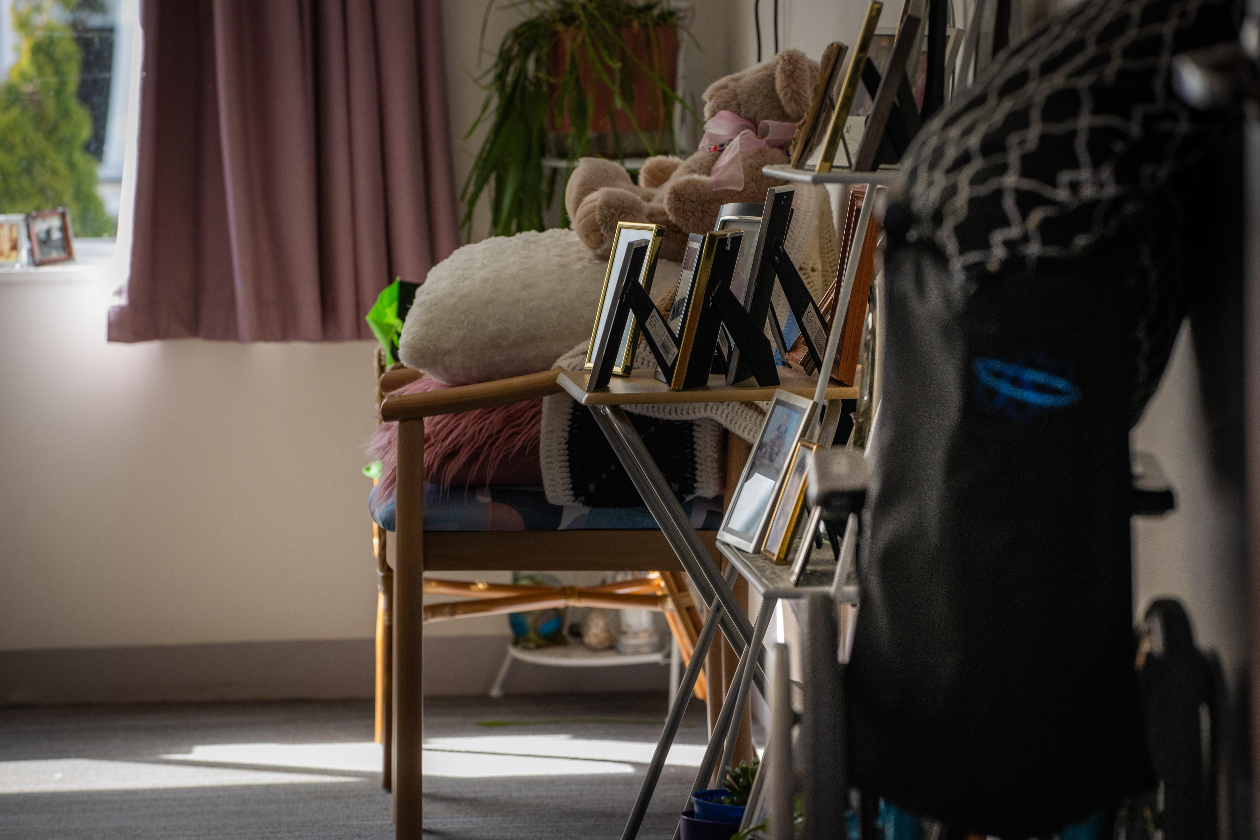 Pictures and frames sit on a side table in an aged care room.