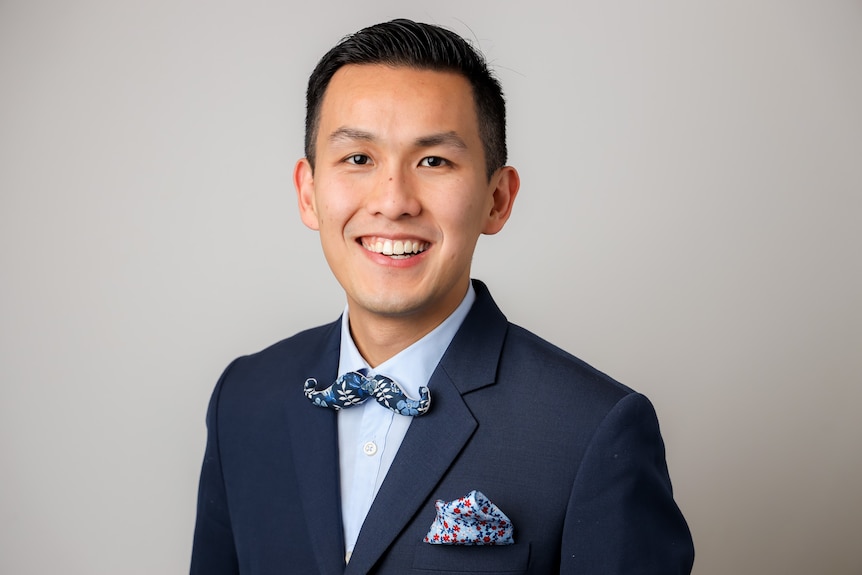 A man in a navy blue jacket with a light blue shirt.