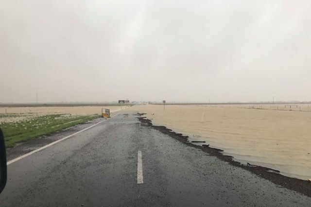 Floodwater runs over the road in Julia Creek in Western Queensland as a result of the rain event in Townsville.