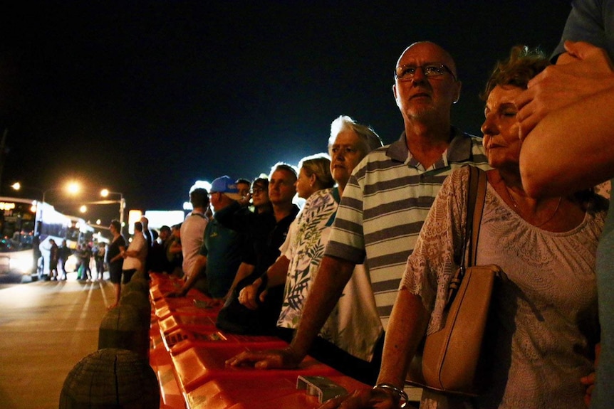 People waiting in darkness to catch a bus