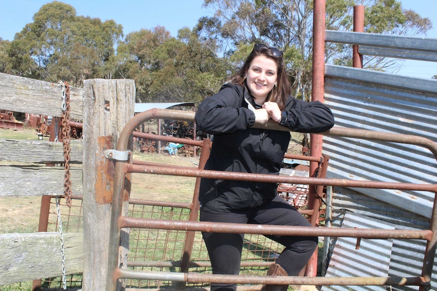 woman standing on a fence