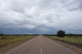 Great Northern Highway stretches into the distance near Fitzroy Crossing with bushland on either side.