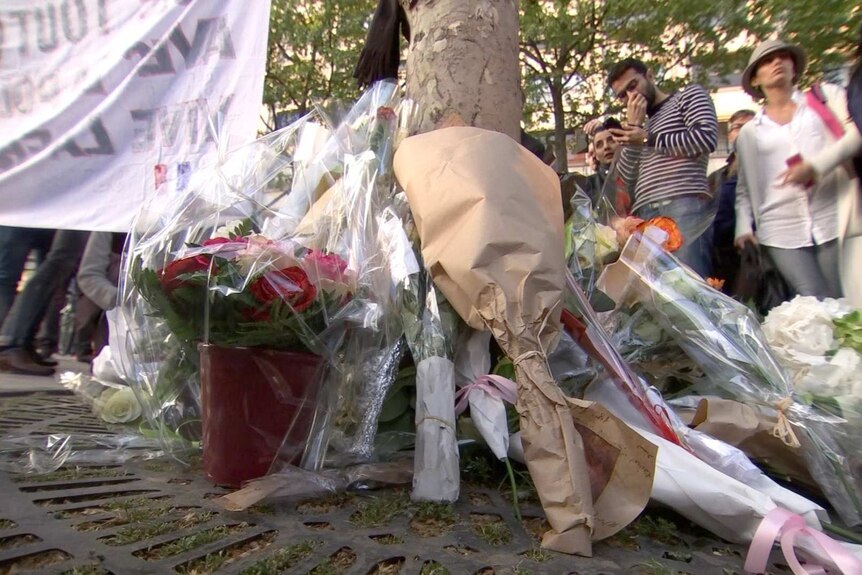 Flowers are laid in a makeshift memorial at the scene of a shooting in Paris.