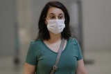 A woman wears a facemask.