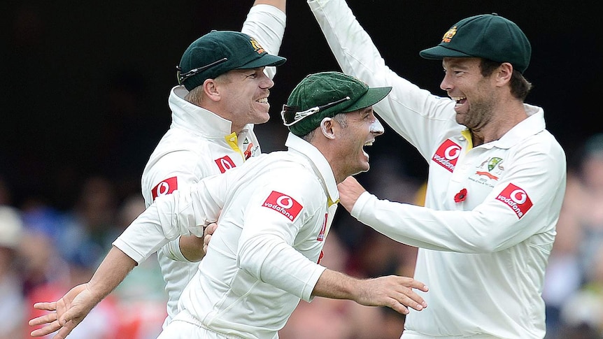 Holding on: Warner, Hussey and Quiney celebrate a fruitful spell after lunch.