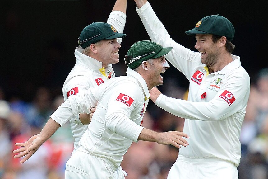 Holding on: Warner, Hussey and Quiney celebrate a fruitful spell after lunch.