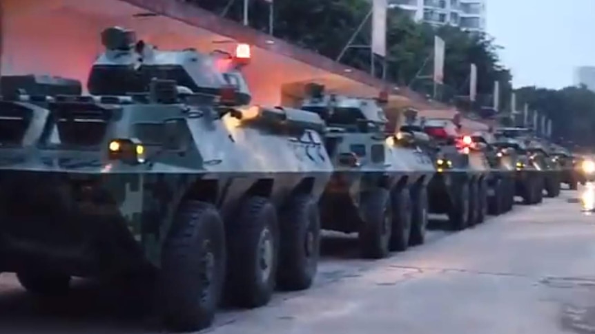 Chinese troops enter Shenzhen in armoured vehicles.