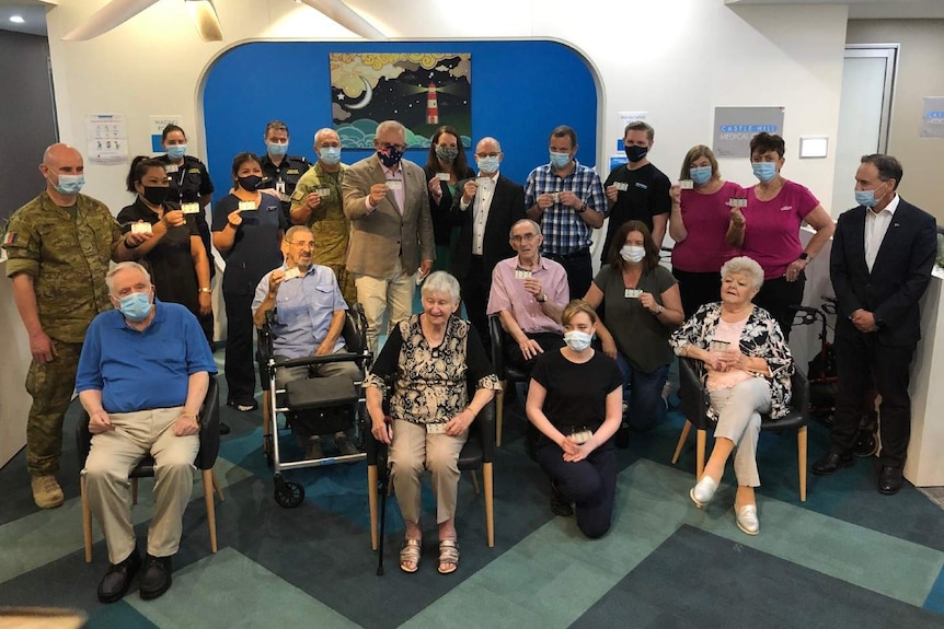 A group of people standing and sitting in a room