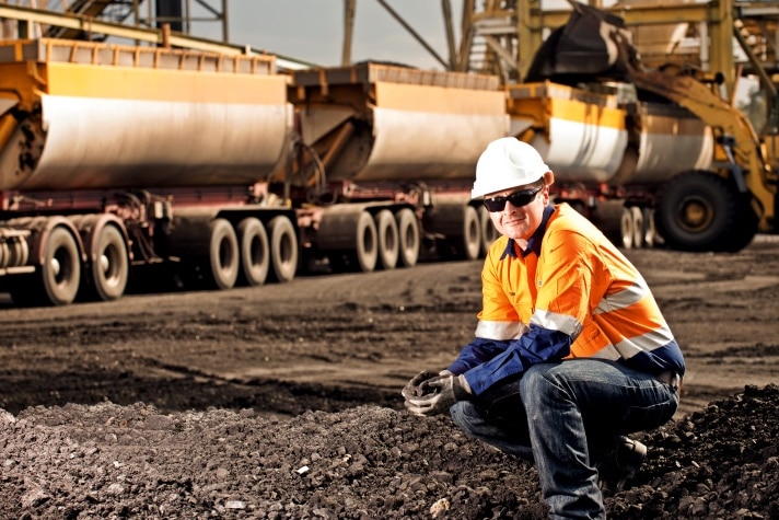 Hunter Valley miner in front of a coal train.