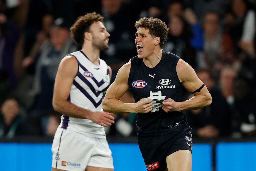 Charlie Curnow pulls on his Carlton jersey in celebration