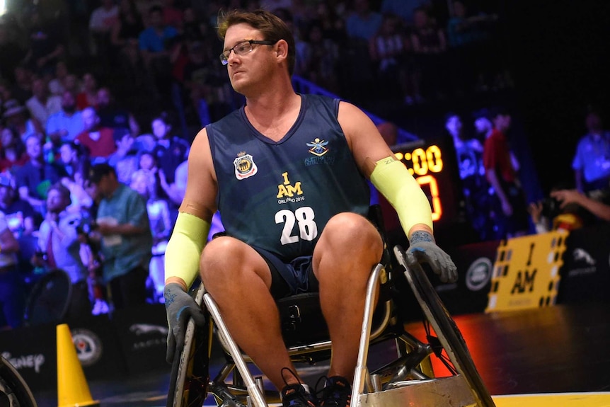 Jamie in a wheel chair with an audience watching