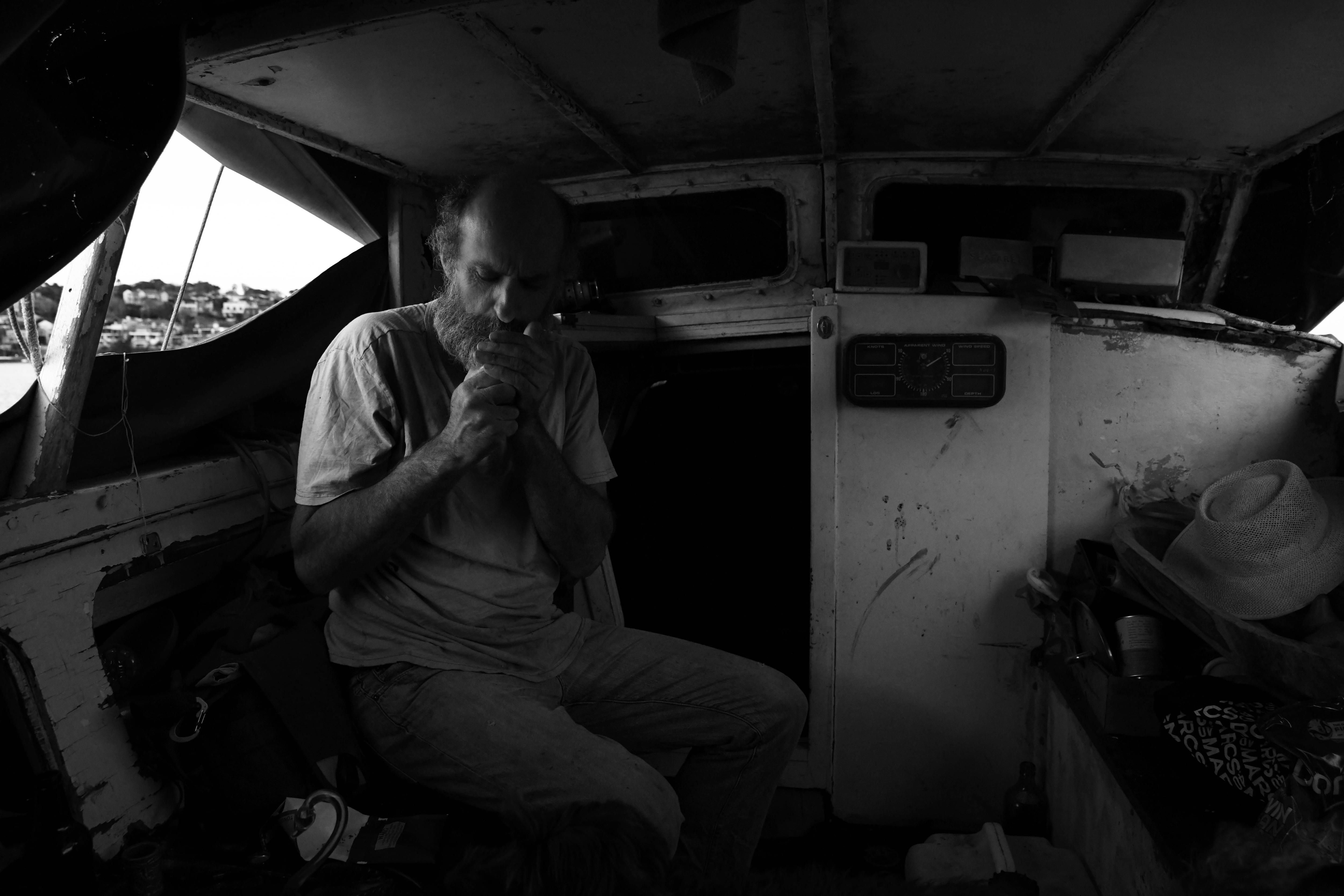 Man covers his hands as he inhales  a cigarette 