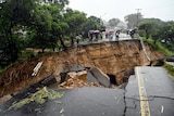  A road connecting the two cities of Blantyre and Lilongwe is collapsed as people look on.
