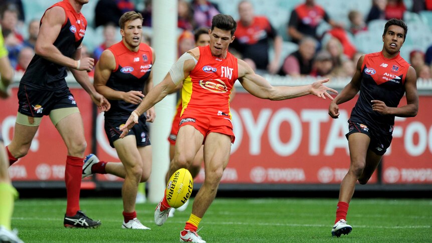 Gold Coast's Jaeger O'Meara clears the ball against Melbourne at the MCG in April 2014.