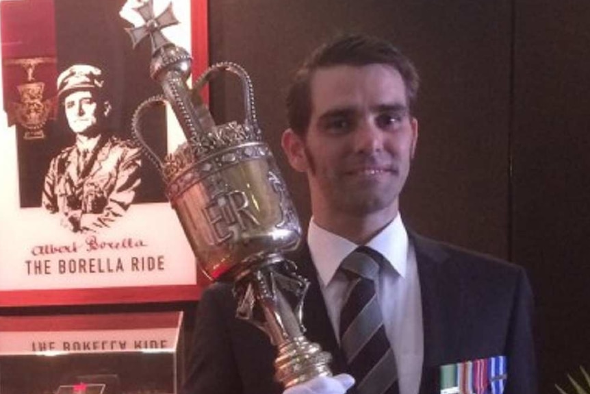 Ben Harris stands in front of a display of Albert Borella's Victoria Cross