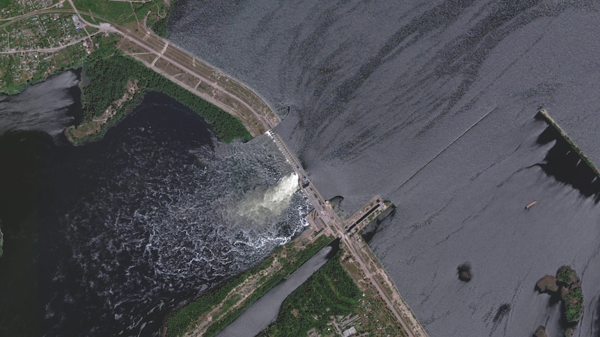 A bird's eye view of a dam split down the middle, hit by russian forces.