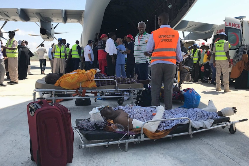 Injured civilians lie on stretchers on the tarmac waiting to board a Turkish military plane