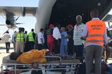 Injured civilians lie on stretchers on the tarmac waiting to board a Turkish military plane