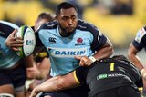 Waratahs prop Sekope Kepu meets the defence of Hurricanes opponent Ben May.