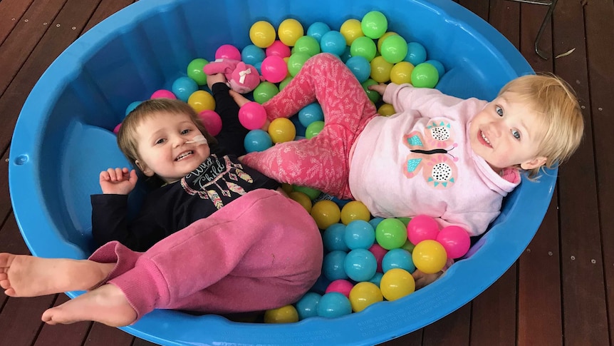 Codee-Jo Phillipps laying in a ballpit with another child