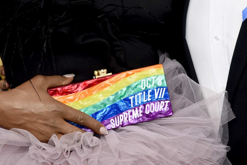 A close-up shot of Laverne Cox holding her rainbow purse.