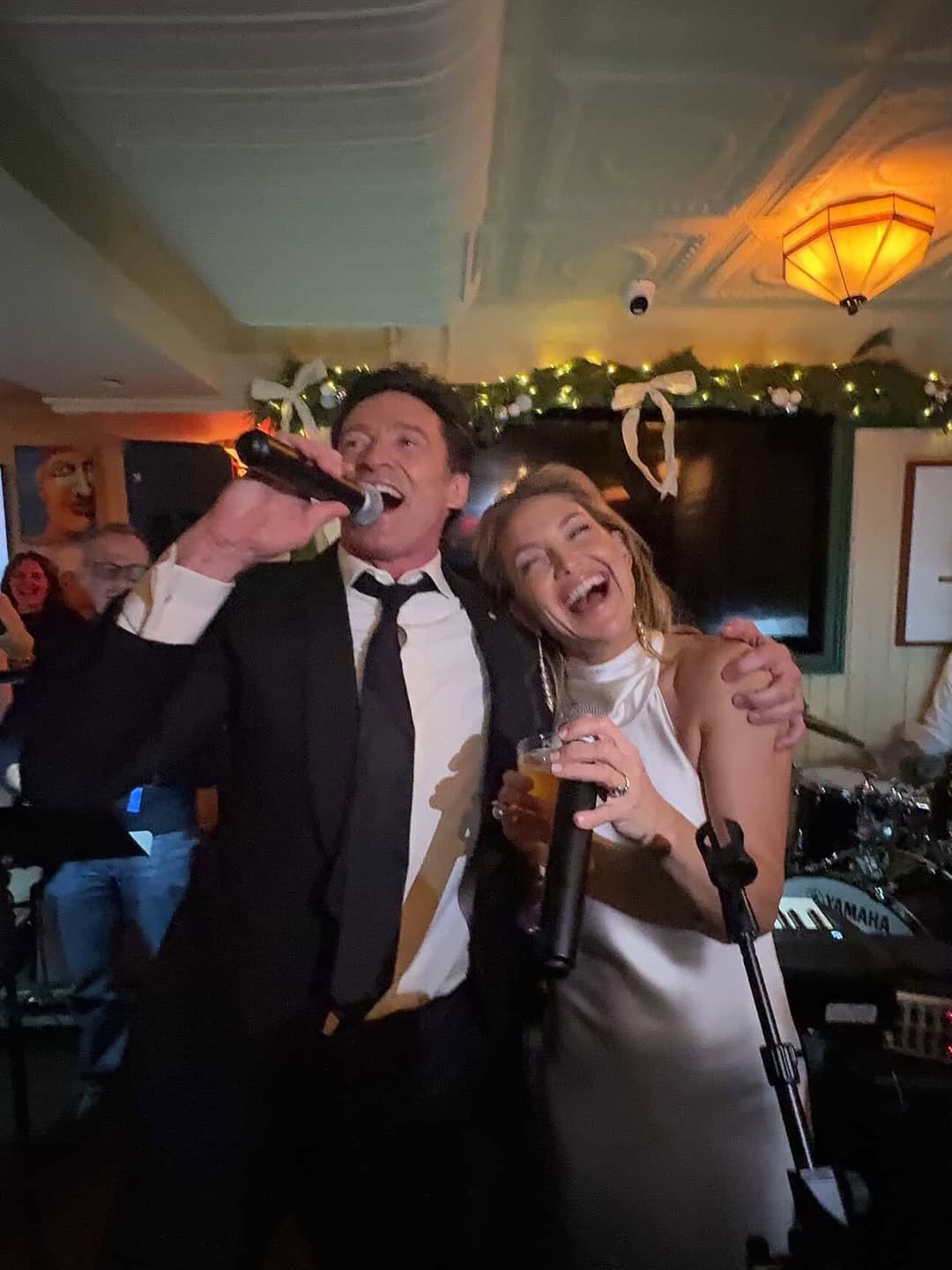 Kate Hudson and Hugh Jackman singing at a pub