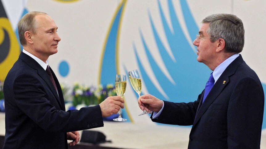 Vladimir Putin toasts a glass of champagne with Thomas Bach.