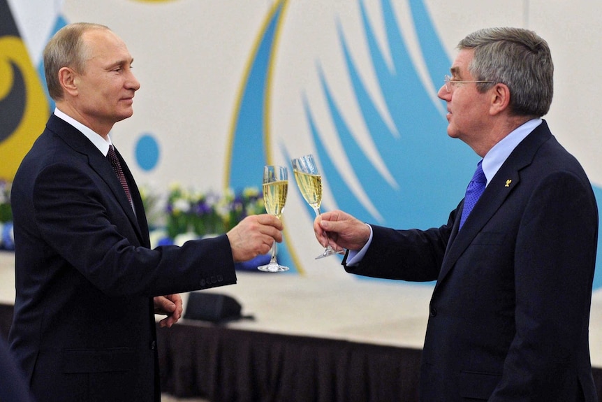 Vladimir Putin toasts a glass of champagne with Thomas Bach.